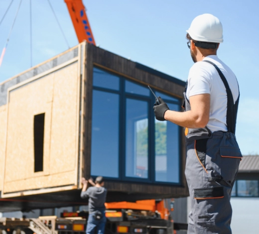 Construction site workers aiding the delivery of off-site timber panels 